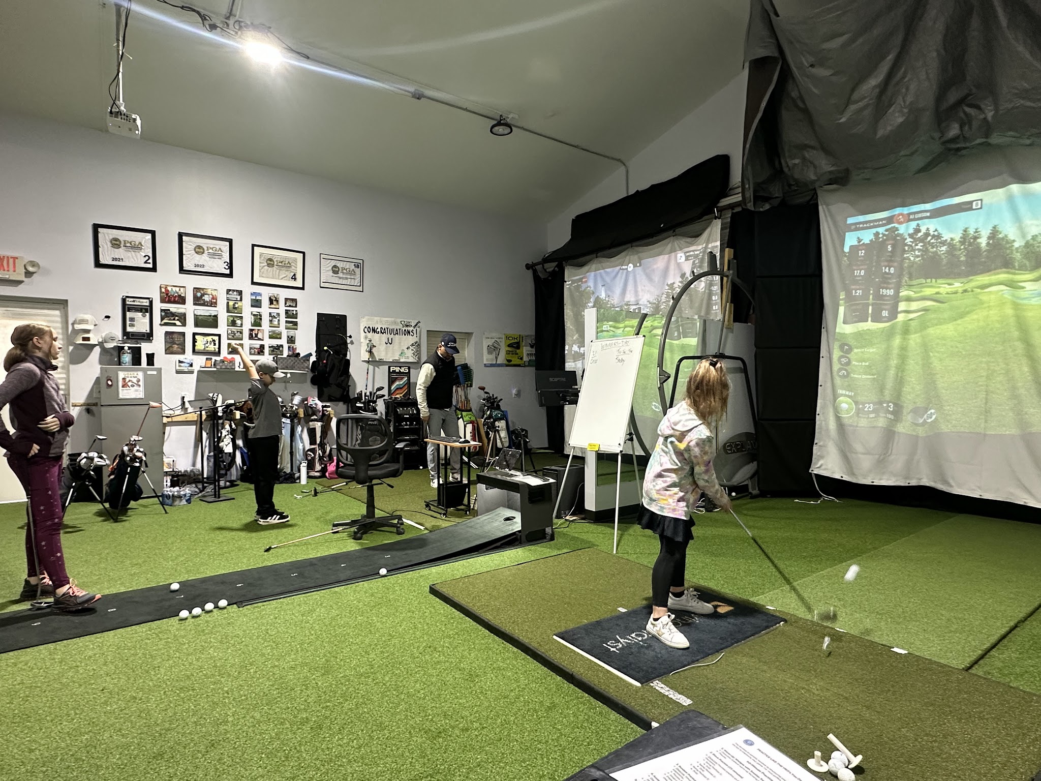Wide view of the Golf Performance Group indoor facility with practice underway